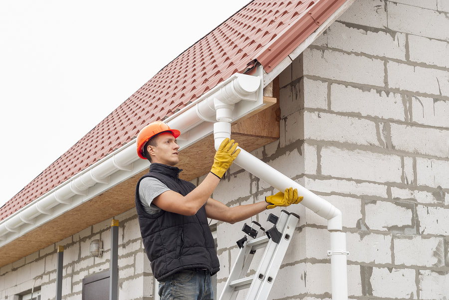 a contractor installing a downspout